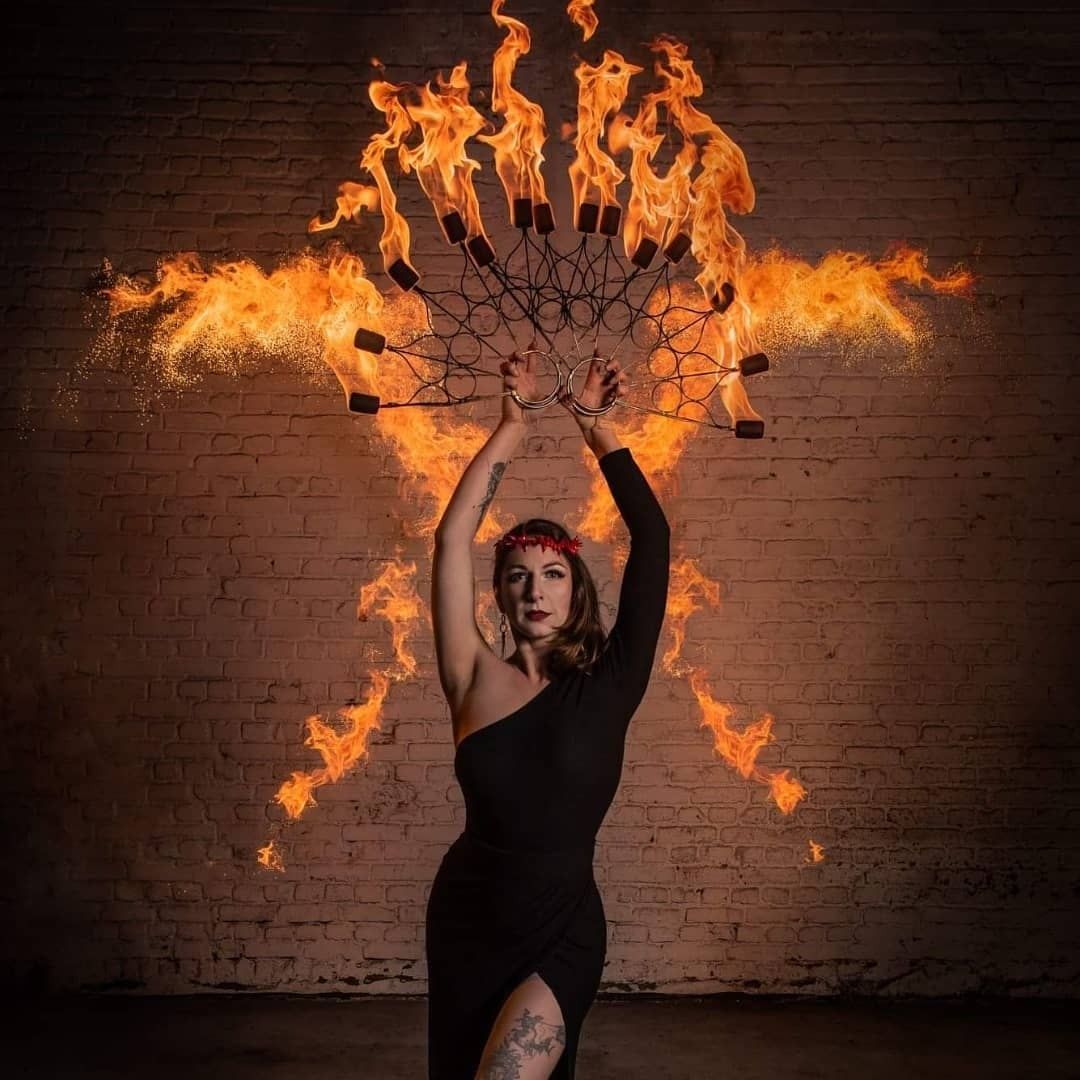 Danseuse en robe noire, éventail de flammes derrière elle