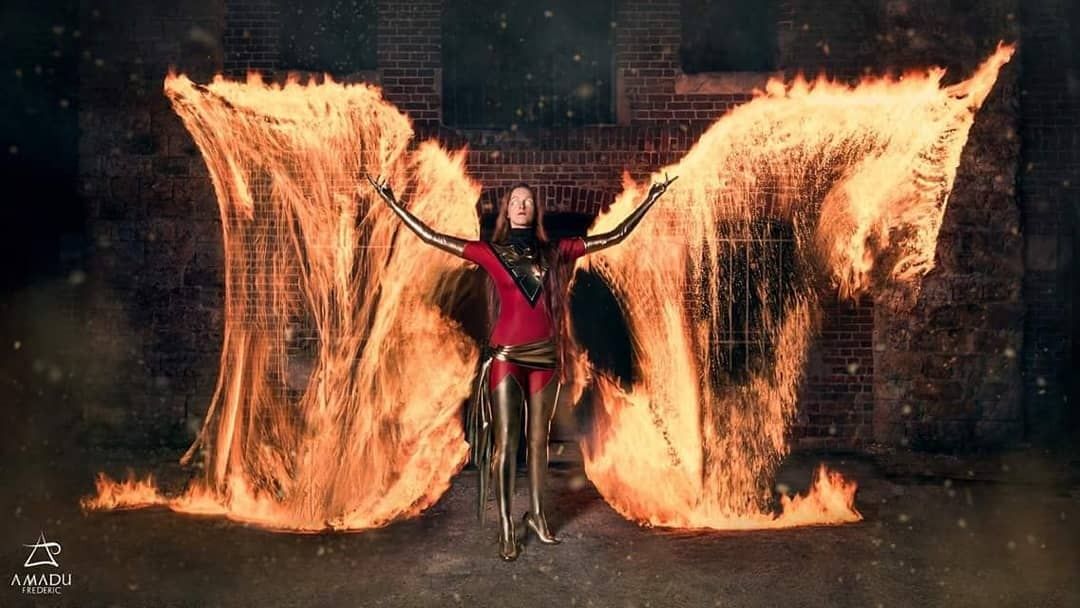 Cosplay Dark Phoenix entre deux grandes ailes de feu