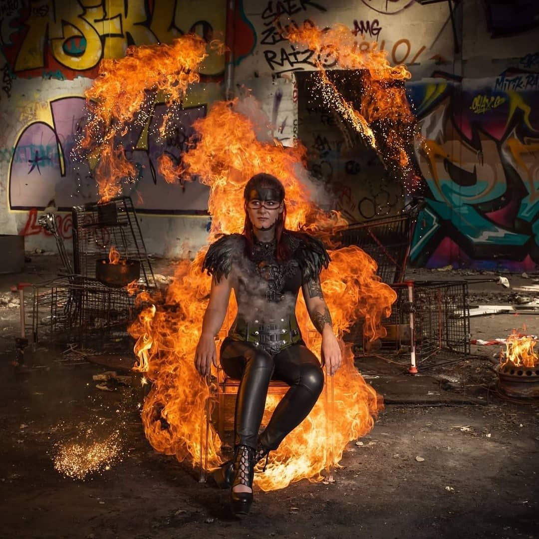 My Wicked Bones assise sur un trône de flammes dans un bâtiment abandonné