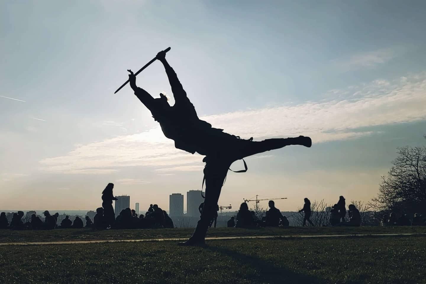 Silhouette au katana en équilibre sur une jambe, au-dessus de Paris